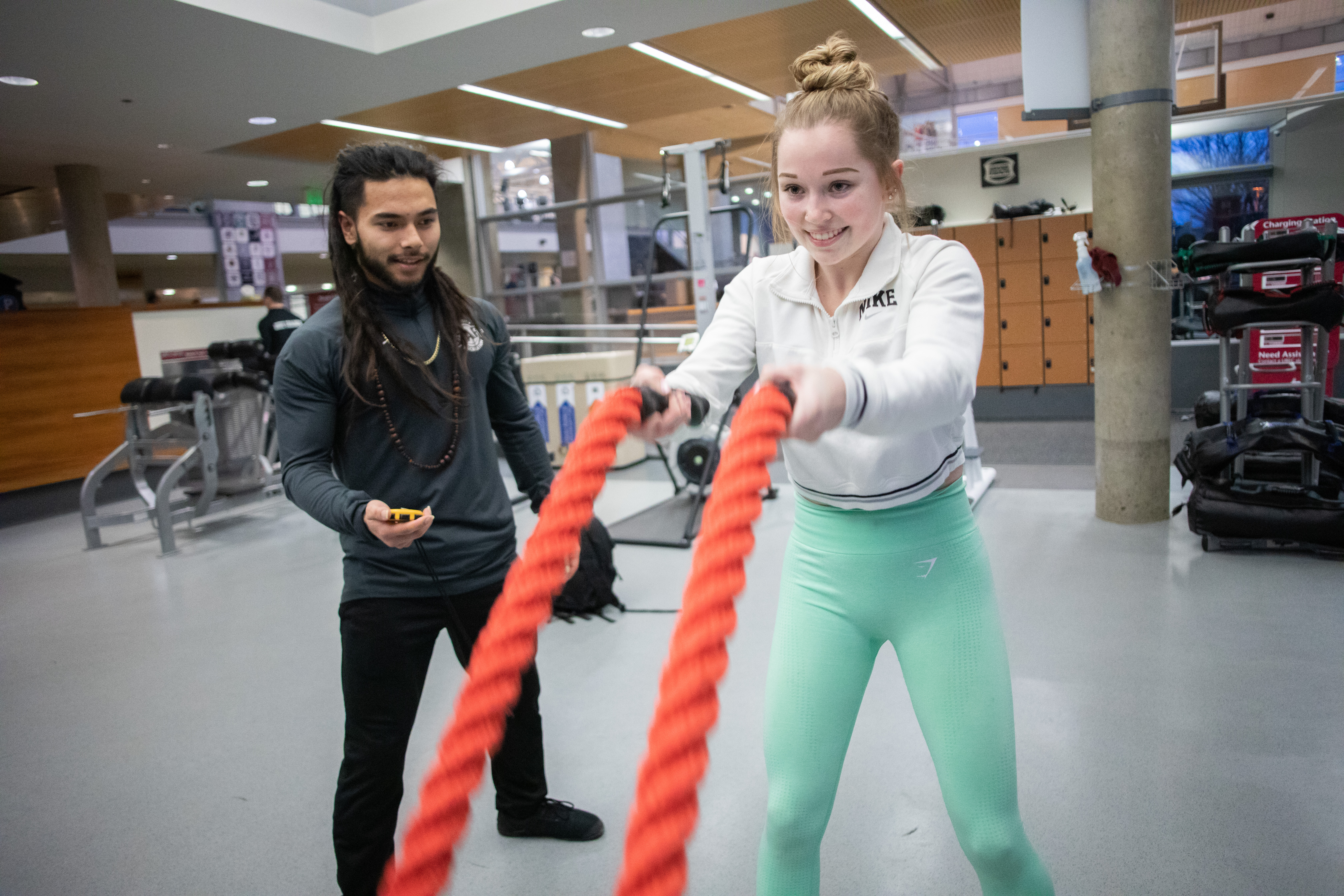 A student works with a personal trainer on strength training at the SRC