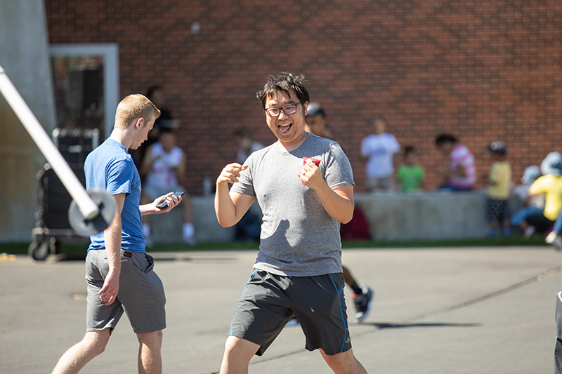 student smiles with bean bag in hand
